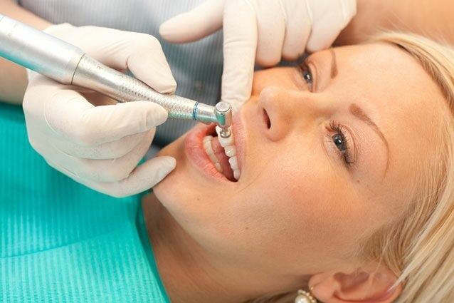 dental hygienist performing a tooth polishing treatment